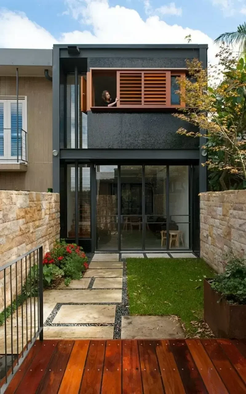 Lối vào nhà 2 tầng hiện đại với sàn gỗ, kính và tường đá
