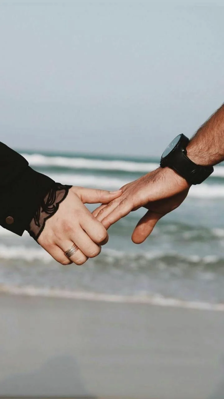Đôi bàn tay nắm nhau trước biển